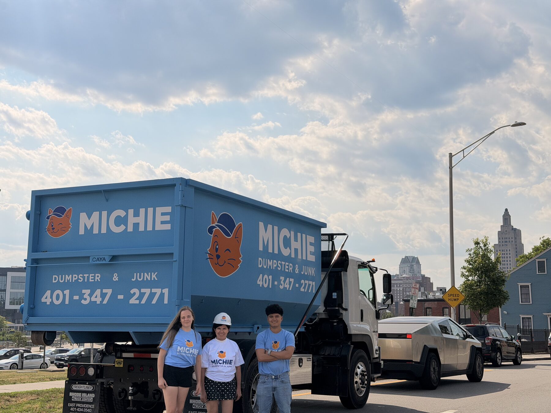 Michie Dumpster & Junk crew standing by a dumpster delivery truck
